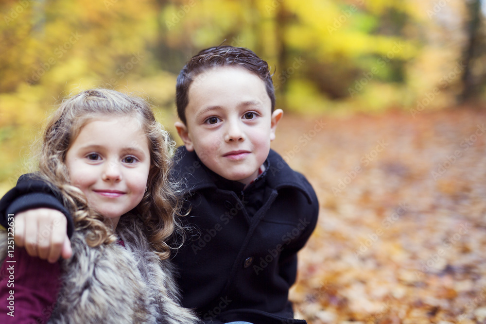children playing in beautiful autumn park on cold sunny fall day. children playing in beautiful autumn park on cold sunny fall day.