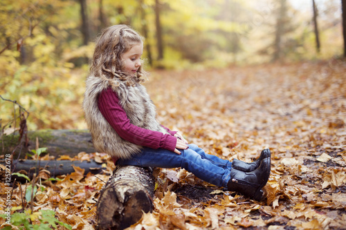 Adorable little girl in a autumn forest