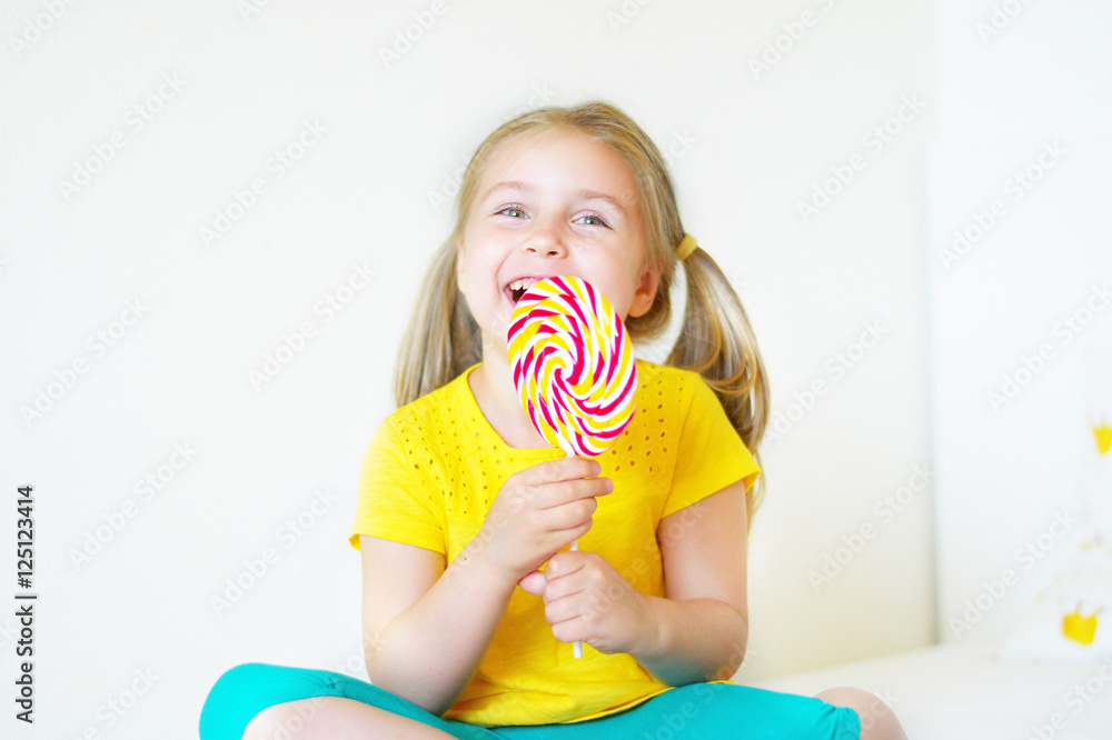 Funny little girl eating big sugar lollipop