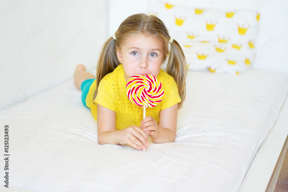 Funny little girl eating big sugar lollipop Funny little girl eating big sugar lollipop