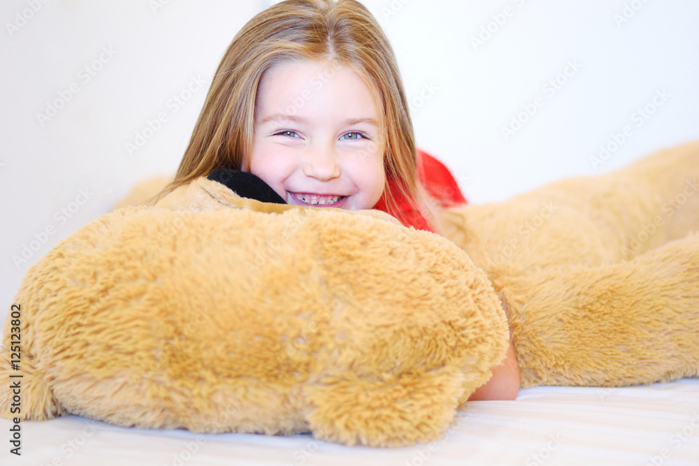 Sweet little girl is hugging a teddy bear while lying in her bed Sweet little girl is hugging a teddy bear while lying in her bed
