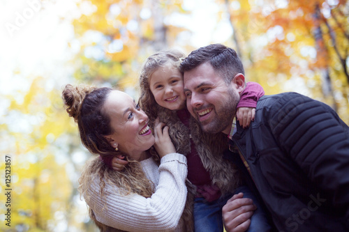 happy young family spending time outdoor in the autumn park