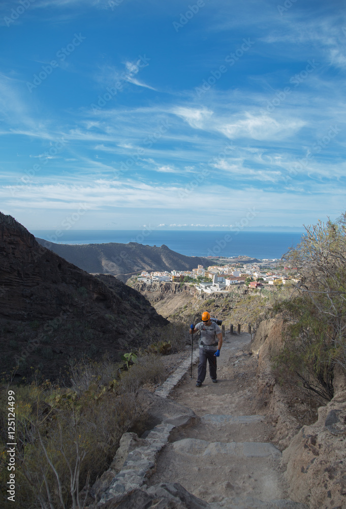 Backpacker man hiking in beautiful landscapes of Barranco del Infierno in Tenerife. Canary islands, Spain
