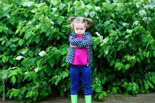 Adorable sad toddler girl at rainy day in autumn