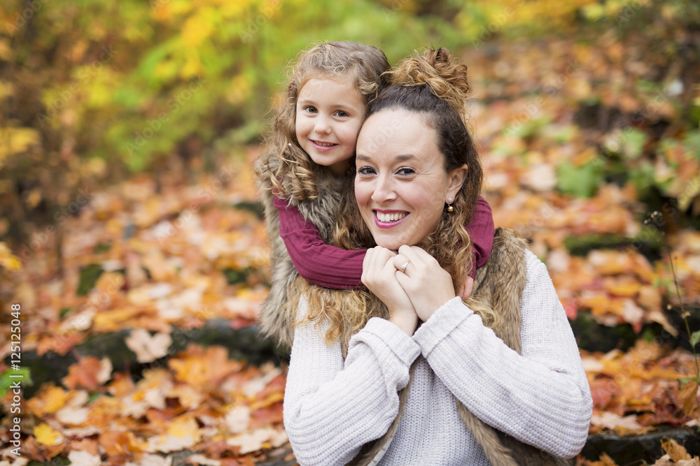 Young mother playing with her daughter in autumn park Young mother playing with her daughter in autumn park