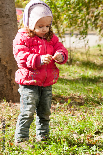 happy little child, baby girl playing in the autumn on the nature walk outdoors