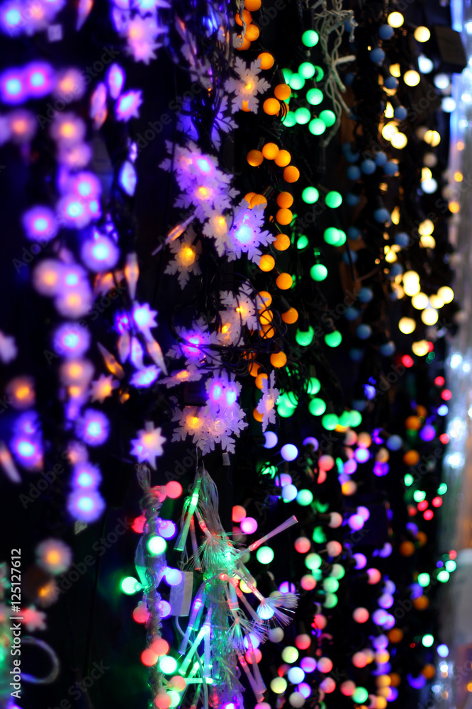 LED lights garland on wall colorful light bulbs on a dark bokeh Christmas and Happy New Years decoration background