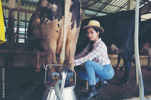 Photos attractive female farmers milkmaid, milking cows on farm