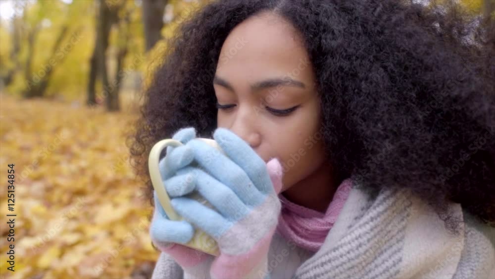 Cute black girl portrait wrapping herself in woolen plaid and drinking hot tea Cute black girl portrait wrapping herself in woolen plaid and drinking hot tea