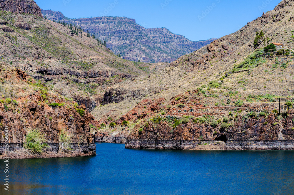 Red mountains, dark water and blue sky Red mountains, dark water and blue sky