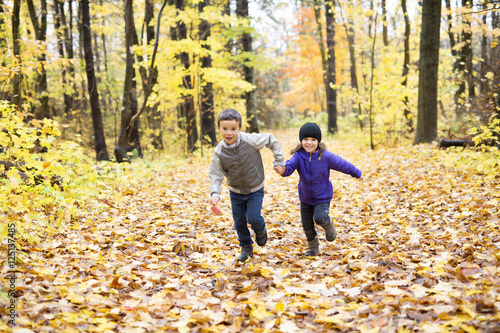 Happy children playing in beautiful autumn park © Louis-Photo