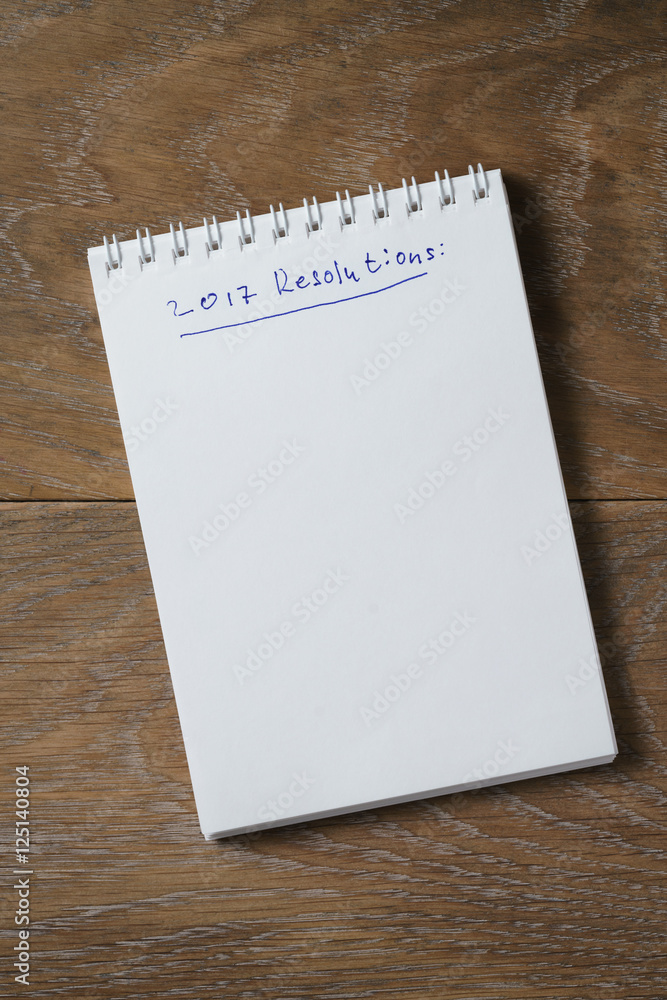 2017 resolutions list on notepad on wood table 2017 resolutions list on notepad on wood table
