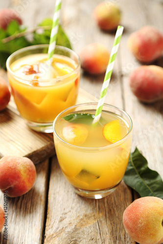 Glasses of peach juice on grey wooden table