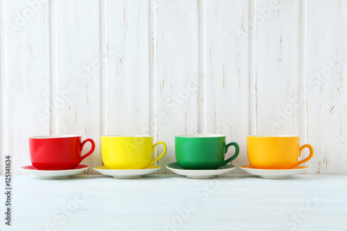 Colorful cups on a blue wooden table