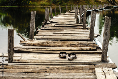 slippers on the Old wooden long bridge cross the lake,Kae Dam Di photo