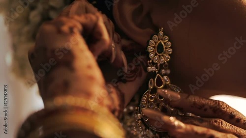 Hindu bride adjusts white flowers in her hair