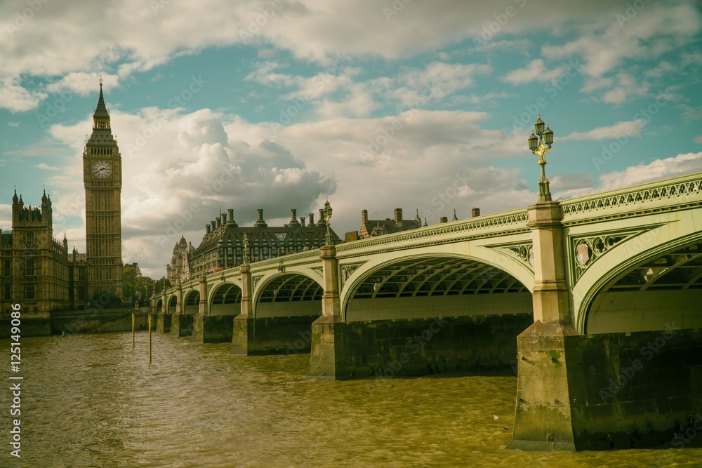 Big Ben with bridge against cloudy sky, London, United Kingdom
