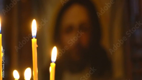 View at the Church From Burning Candles Face of Christ in the Icon. Lick Holy Flame Lit Candles.