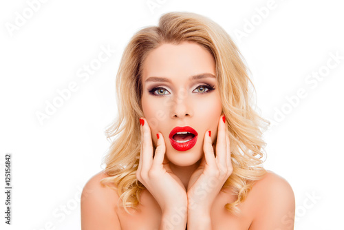 Wow! Portrait of surprised beautiful young blonde touching face