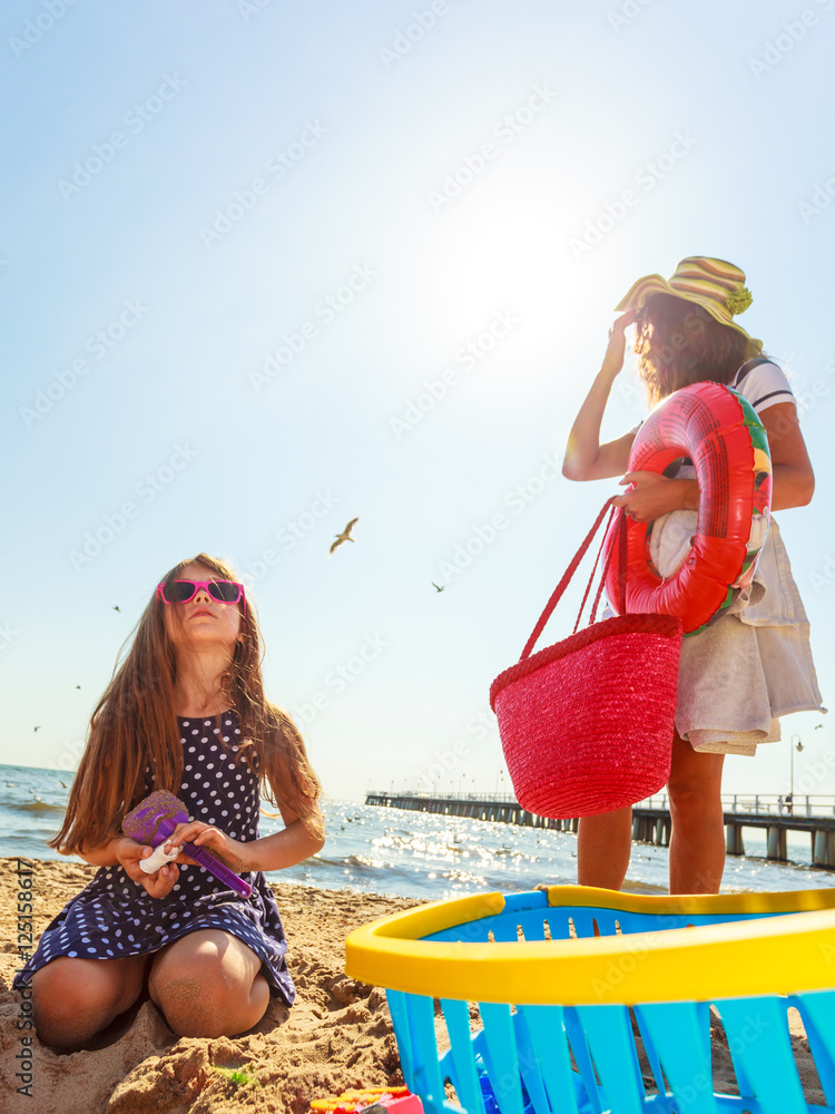 Obraz premium Mother and daughter playing on beach.
