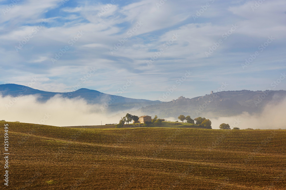 Scenic view of Tuscan fields and hills with fog
