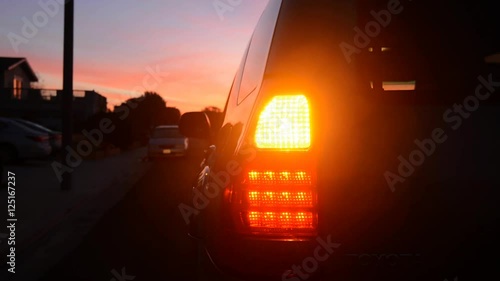 A car blinker and taillight at night used for safety and signaling for turns..