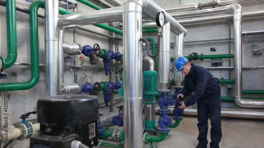 Man working in a factory, controls the operation of devices in a Heating Plant Man working in a factory, controls the operation of devices in a Heating Plant