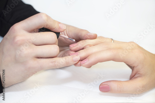 Manicurist doing manicure  in salon.