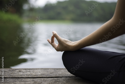 Close up hand. Woman do yoda outdoor. Woman exercising yoga at the nature background, select focus