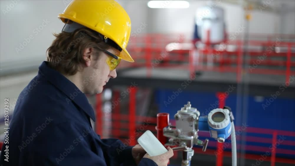 Man working in a factory, controls the operation of devices in a power plant Man working in a factory, controls the operation of devices in a power plant