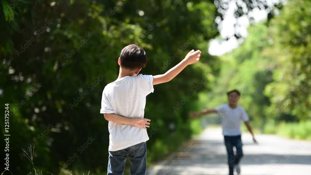 Two boy walk and run and wave their hand to meet each other on the urban road and park. Two boy walk and run and wave their hand to meet each other on the urban road and park.