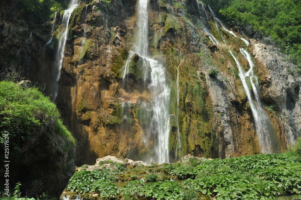 High waterfall, the water flowing from the rocks into the lake. National Park Plitvice Lakes. Tourism in Croatia. High waterfall, the water flowing from the rocks into the lake. National Park Plitvice Lakes. Tourism in Croatia.