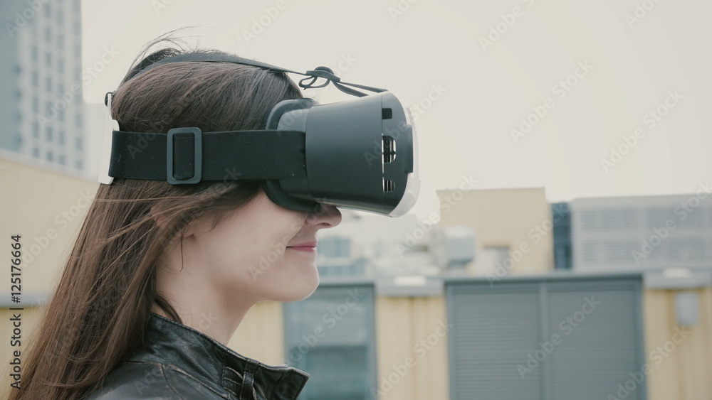 Brunette woman girl with waving hair uses a virtual reality glasses on the roof. 4k Brunette woman girl with waving hair uses a virtual reality glasses on the roof. 4k