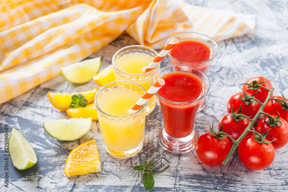 orange and tomato juice in glasses on a table, selective focus orange and tomato juice in glasses on a table, selective focus