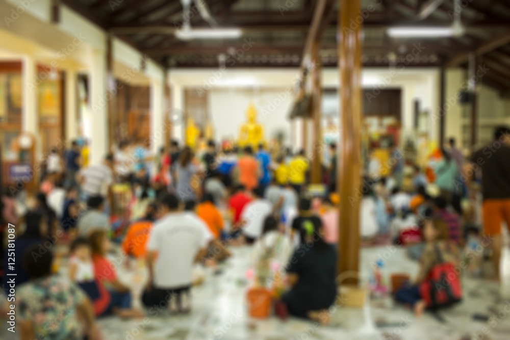 blurred image with people make something good in temple for back