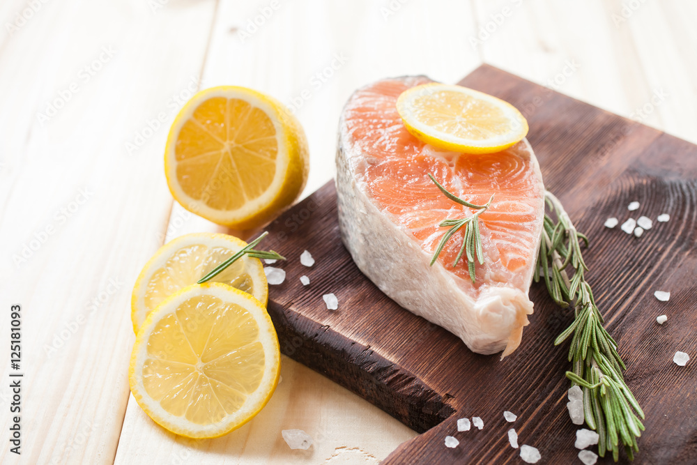 stake of a salmon with a lemon and vegetables on a table, selective focus stake of a salmon with a lemon and vegetables on a table, selective focus
