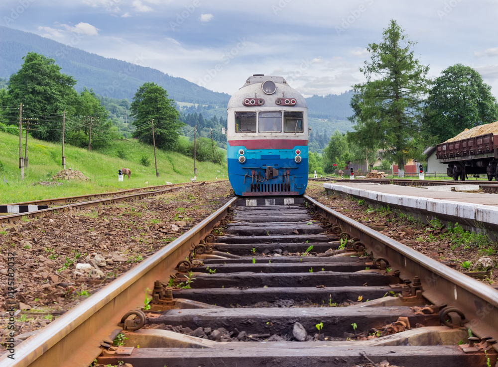 Fototapeta premium Old train on the railroad tracks on railway station in Carpathians