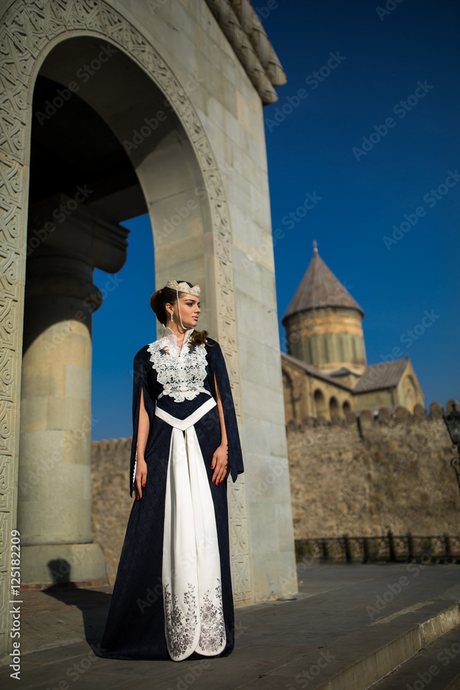 beautiful young Georgian girl near old castle