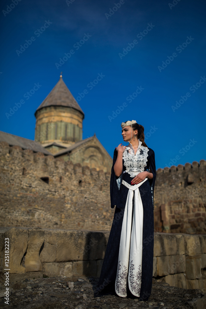 beautiful young Georgian girl near old castle