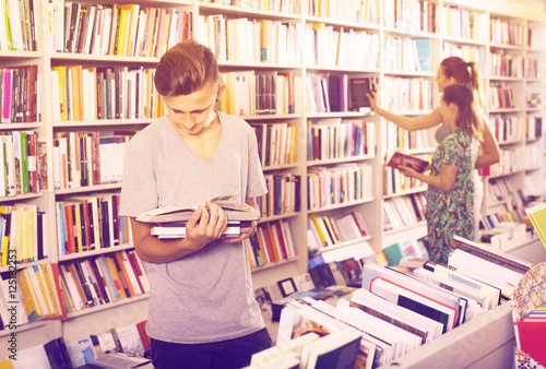 teenager boy reading book in shop. © JackF