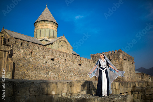beautiful young Georgian girl near old castle