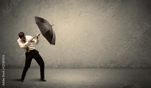 Handsome business man holding umbrella with copy space backgroun