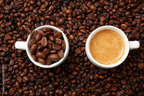 Cups with hot coffee and coffee beans, close up view