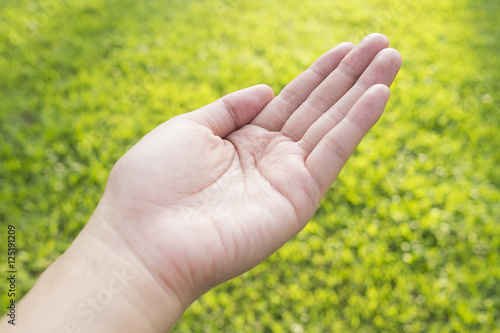 Open empty woman female hand on green field background © ieang