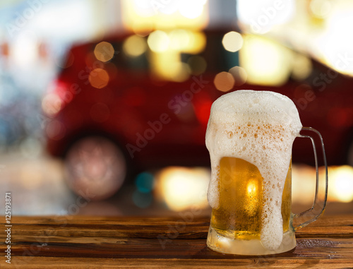 cold mug of beer with foam on the background of the street