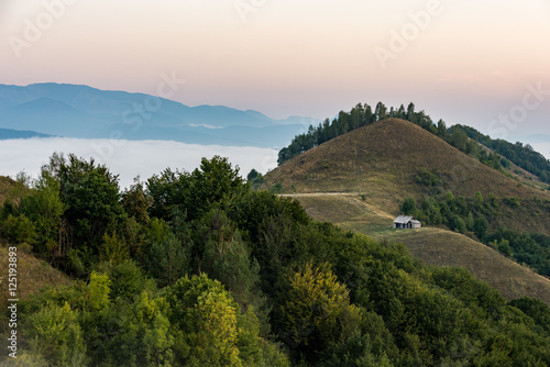 Romanian countryside landscape with wooden hut in Apuseni Mountains