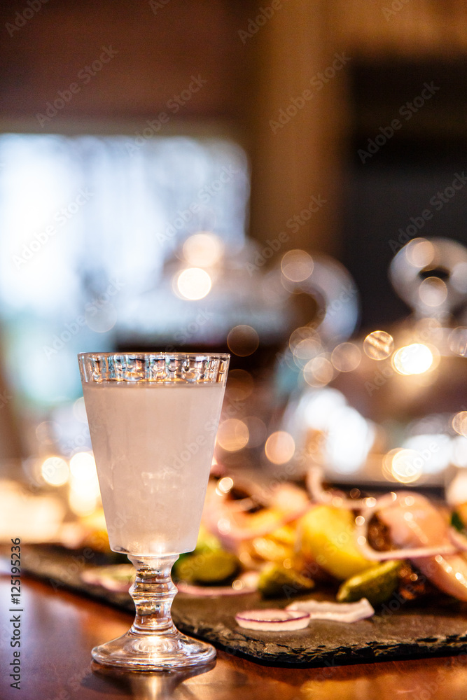 Russian vodka is poured into a frozen glass. Evening, gala dinne