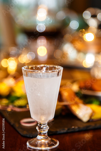 Russian vodka is poured into a frozen glass. Evening, gala dinne