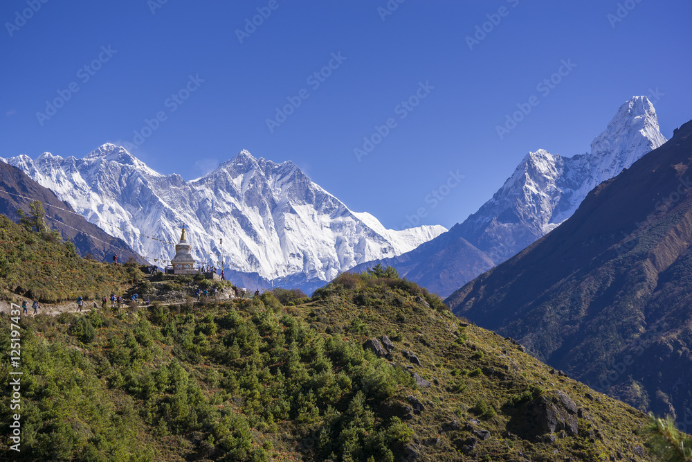 View of a Buddhist stupa with mountain Lhotse and Ama Dablam behind on the way from Namche Bazaar to Tengboche of the everest base camp trekking route.