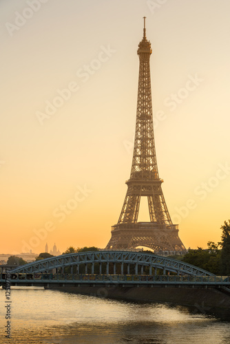 Warm sunrise light on the Eiffel Tower and the Seine River in Paris, France. The view includes the Pont Rouelle bridge and in the distance, the Basilica of the Sacred Heart (Sacre Coeur). © Francois Roux